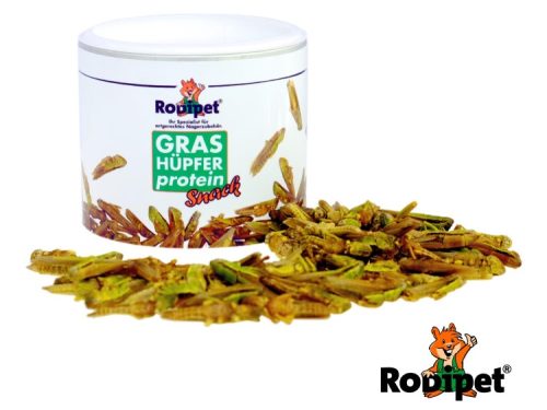 Proteinholdig snack til gnavere fra Rodipet, præsenteret i en beholder med græshopper, der også er spredt omkring. Ideel til mindre kæledyr som marsvin og kaniner for en sund og lækker treat.