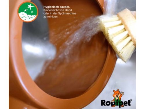 Billede, der viser rengøring af en rodipet skål til gnavere, med varmt vand og en børste. Produktet er let at rengøre enten i hånden eller i opvaskemaskinen, hvilket gør det ideelt til kæledyrspleje. | gnavernes univers